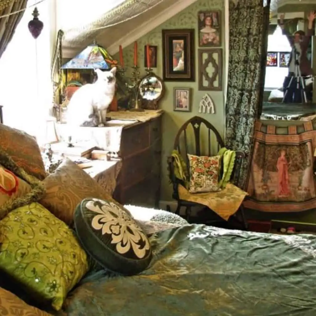 Mossy green room with lots of pictures, floral pillows and more