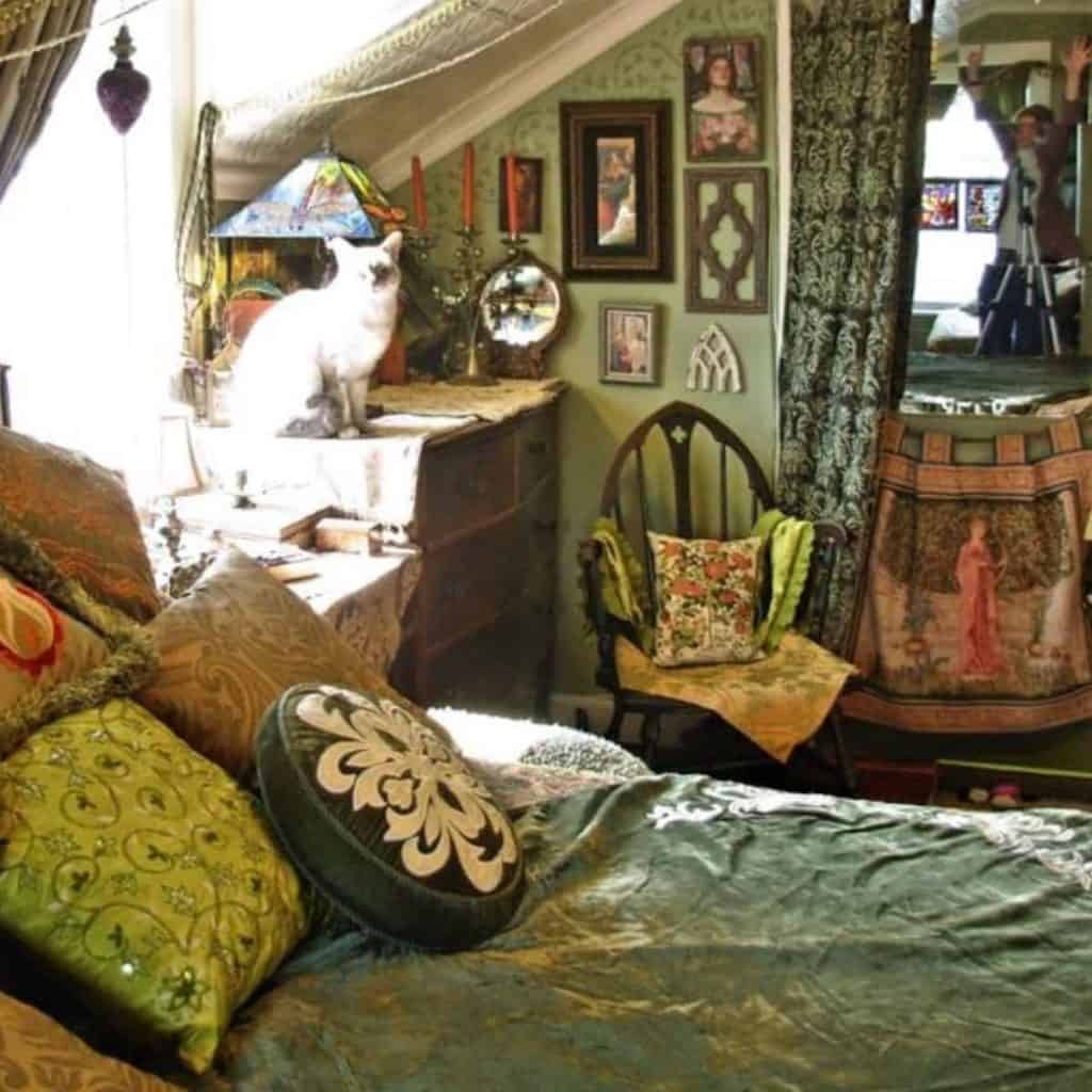 Mossy green room with lots of pictures, floral pillows and more